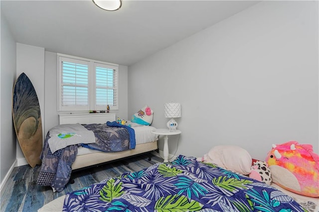 bedroom featuring wood finished floors and baseboards