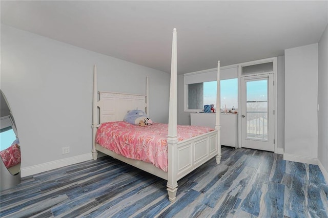 bedroom with access to outside, dark wood-style floors, and baseboards