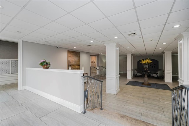 interior space with ornate columns, recessed lighting, a paneled ceiling, and baseboards