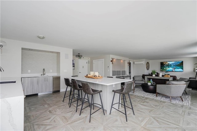 kitchen featuring light countertops, a kitchen breakfast bar, a sink, a kitchen island, and open floor plan