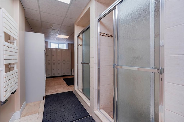 full bath with a shower stall and a drop ceiling