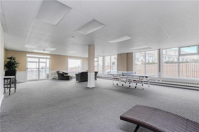 rec room with a paneled ceiling, carpet floors, wainscoting, and a baseboard radiator
