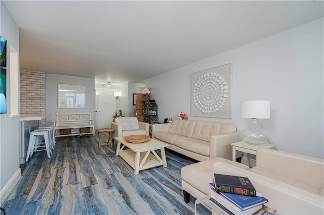 living room with wood finished floors, a wood stove, and baseboards