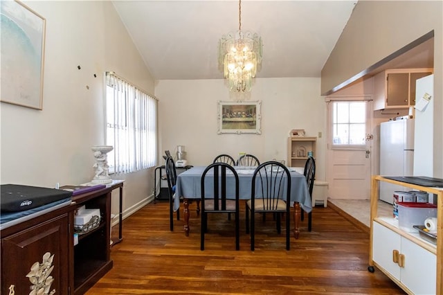 dining room with a chandelier, lofted ceiling, and dark wood-style floors