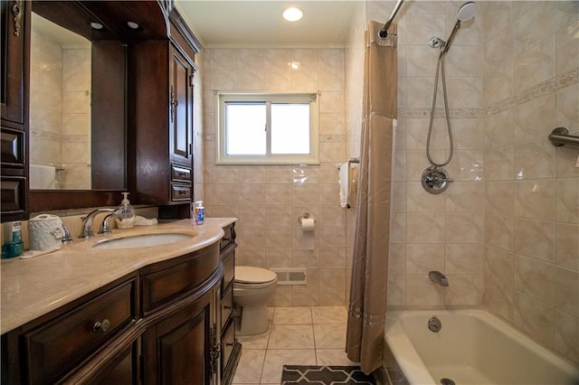 full bathroom featuring toilet, tile walls, tile patterned flooring, vanity, and shower / bath combo