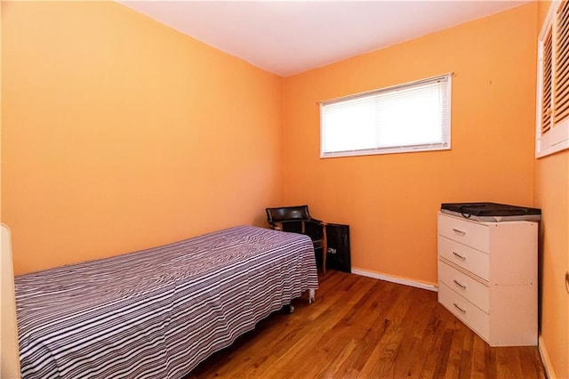 bedroom with wood finished floors and baseboards