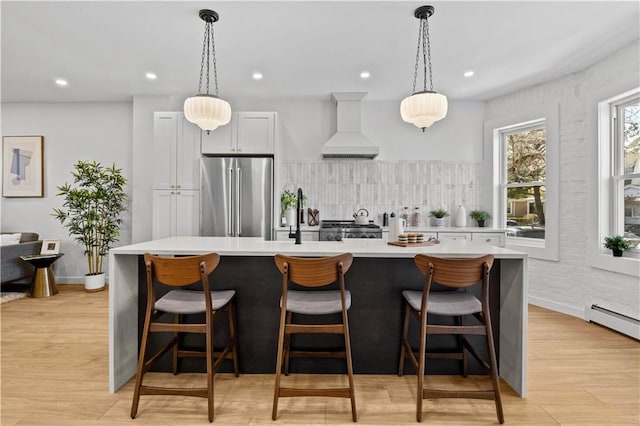 213 E 9th St, Brooklyn, NY 11218 - kitchen featuring high end refrigerator, custom exhaust hood, light countertops, a kitchen island, and decorative backsplash