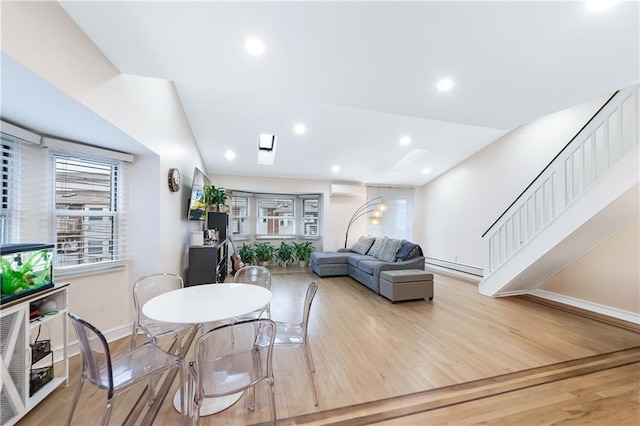 living area with wood finished floors, baseboards, recessed lighting, a wall mounted AC, and baseboard heating