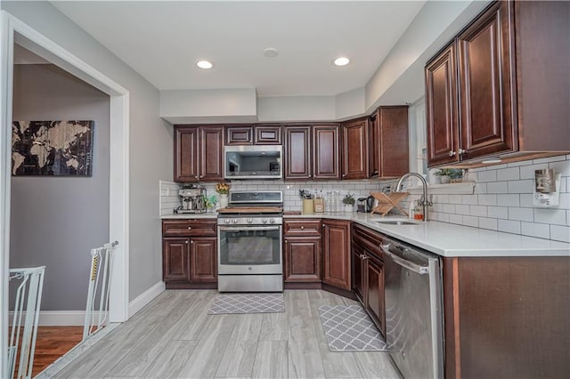 341 Hillman Ave, Staten Island, NY 10314 - kitchen with stainless steel appliances, a sink, light countertops, decorative backsplash, and light wood-type flooring