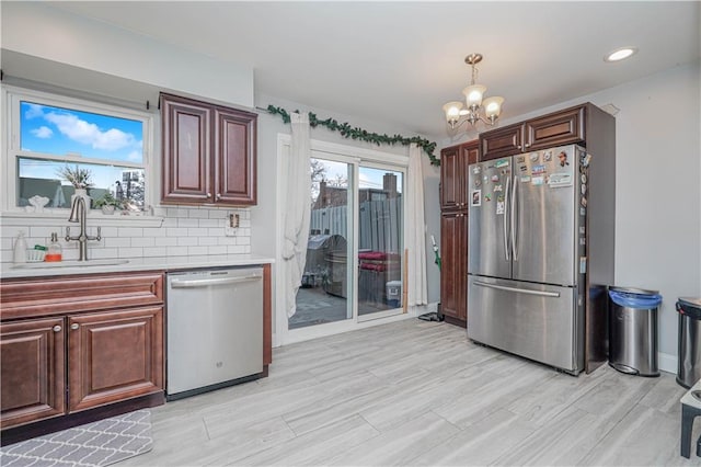 341 Hillman Ave, Staten Island, NY 10314 - kitchen featuring appliances with stainless steel finishes, a sink, light countertops, a chandelier, and tasteful backsplash