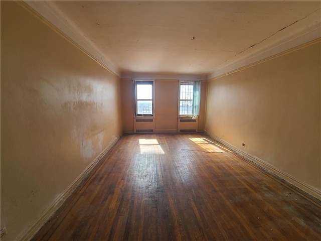spare room featuring hardwood / wood-style floors, baseboards, and ornamental molding
