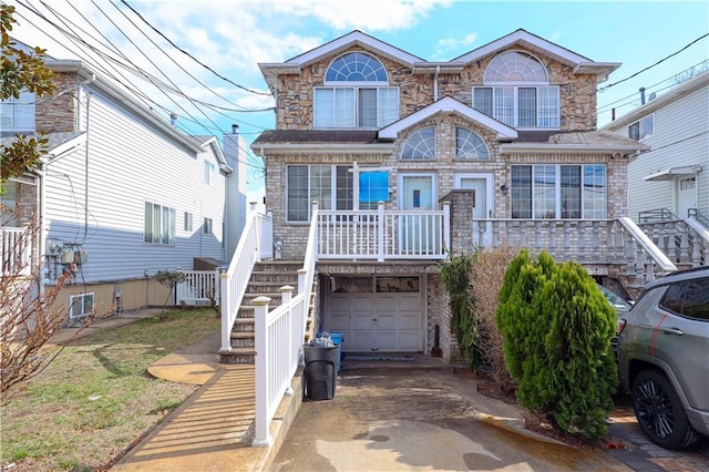 view of front of house featuring a porch, stone siding, a garage, stairway, and driveway