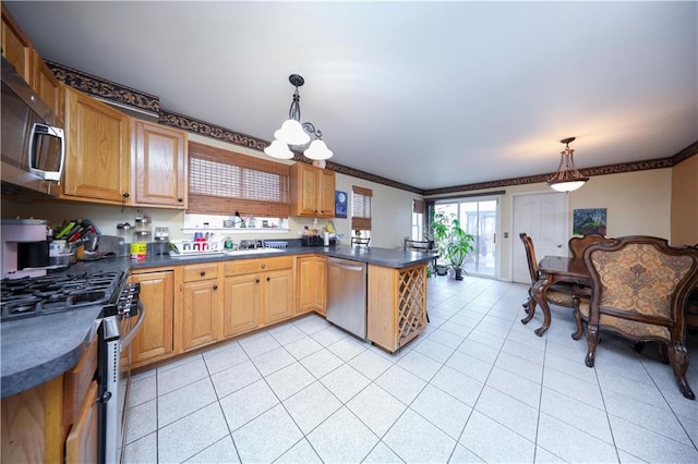 kitchen with light tile patterned floors, a peninsula, ornamental molding, appliances with stainless steel finishes, and dark countertops