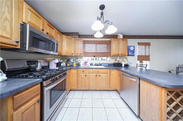 kitchen featuring dark countertops, a notable chandelier, and appliances with stainless steel finishes