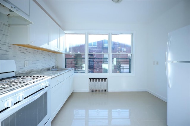 11 Brighton 10th Path, Brooklyn, NY 11235 - kitchen featuring white appliances, radiator, under cabinet range hood, white cabinets, and tasteful backsplash