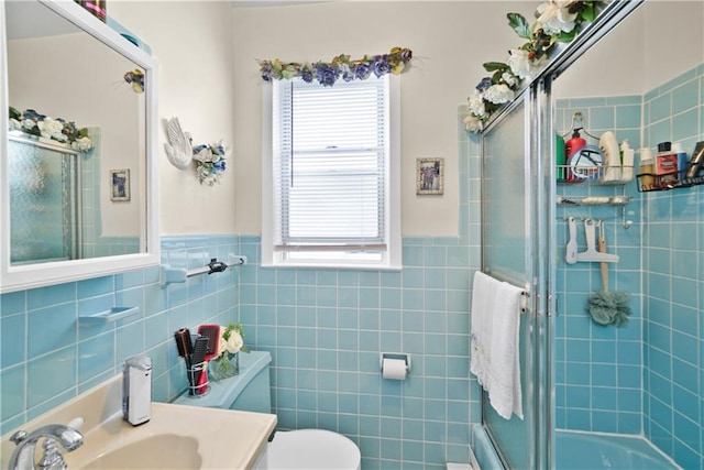 full bath with tile walls, an enclosed shower, plenty of natural light, toilet, and wainscoting