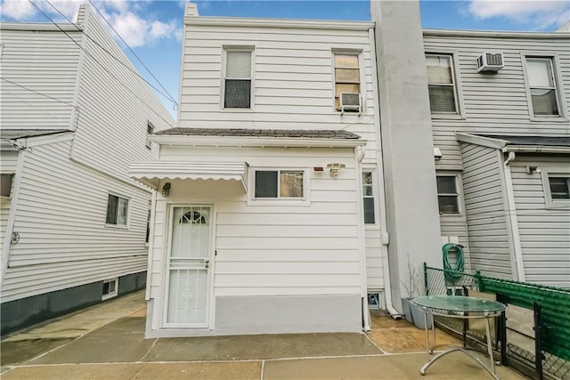 rear view of house with a patio area and a wall mounted air conditioner