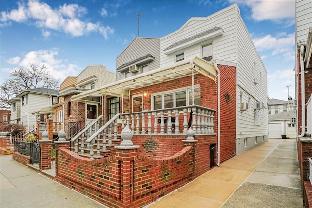 multi unit property with brick siding, a residential view, and a detached garage