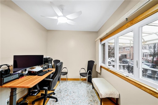 office space featuring wood finished floors, ceiling fan, and baseboards