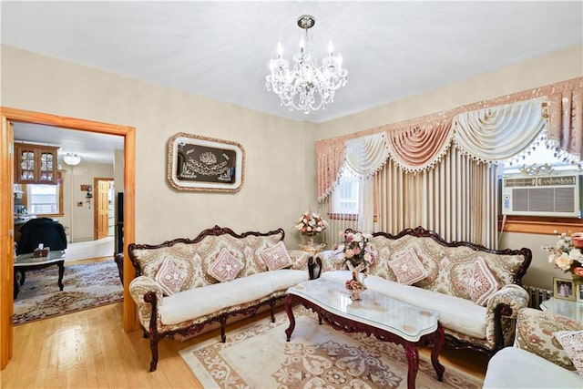 living room featuring a chandelier, wood finished floors, and cooling unit