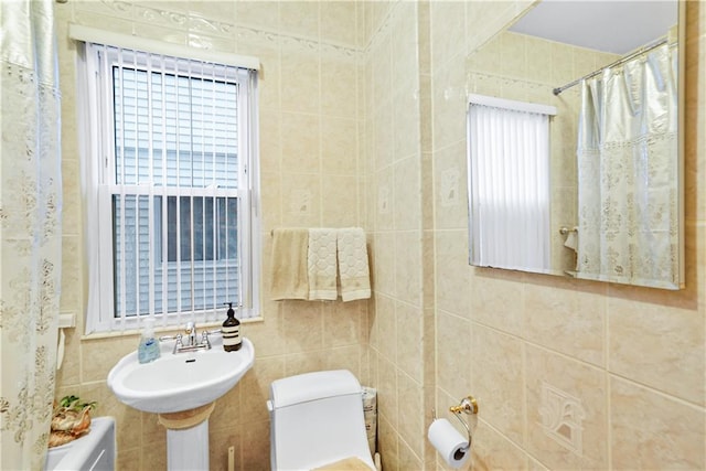 bathroom with toilet, a shower with curtain, and tile walls
