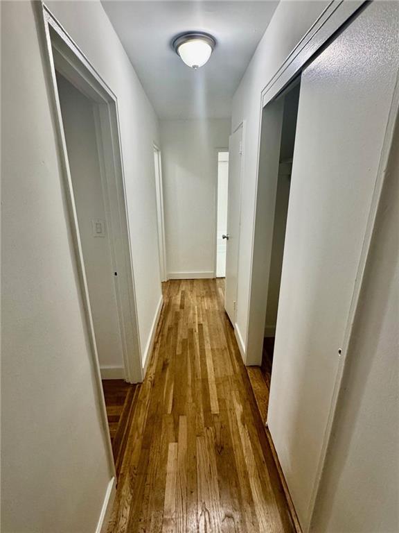 2800 Coyle St Unit 616, Sheepshead Bay, NY 11235 - hallway with baseboards and hardwood / wood-style flooring