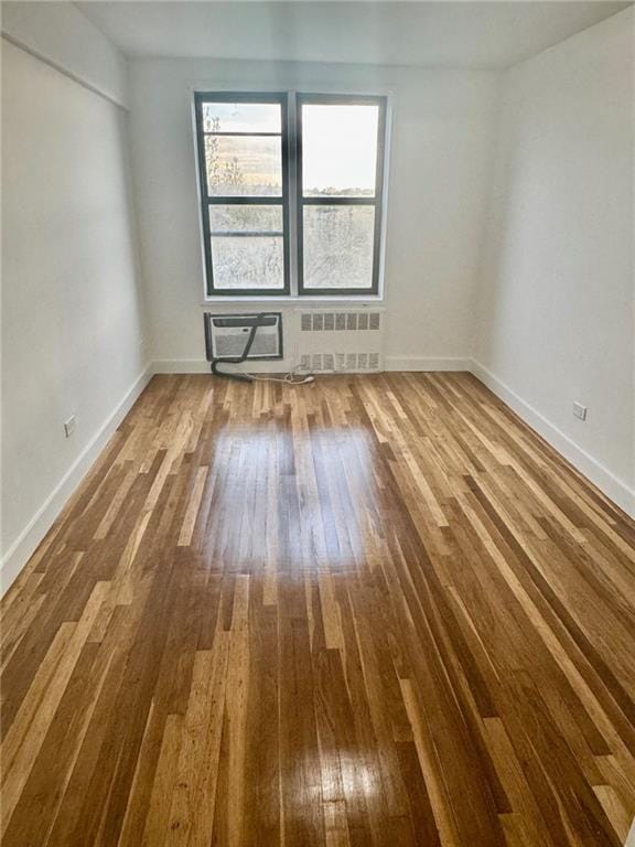 2800 Coyle St Unit 616, Sheepshead Bay, NY 11235 - unfurnished room with wood finished floors, a wall unit AC, baseboards, and radiator