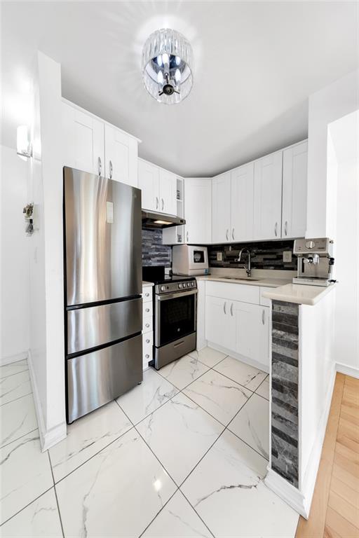 kitchen featuring wine cooler, a sink, appliances with stainless steel finishes, under cabinet range hood, and marble finish floor