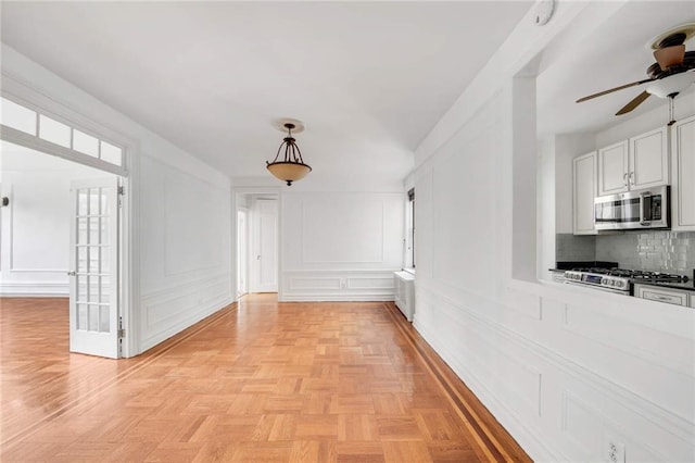 interior space featuring ceiling fan and a decorative wall