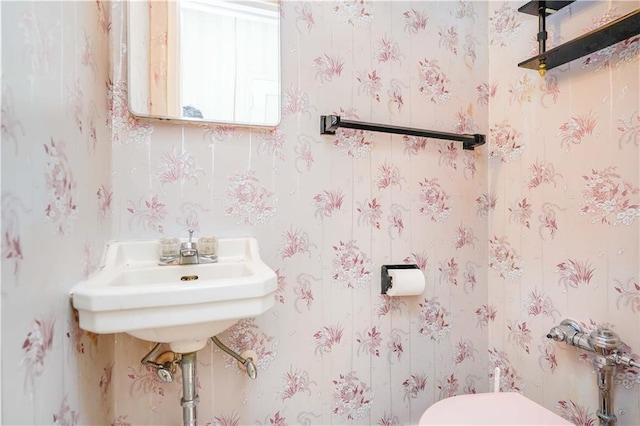 bathroom with toilet and wallpapered walls