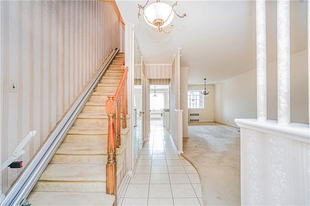 stairs with a chandelier, radiator heating unit, carpet flooring, tile patterned floors, and baseboards