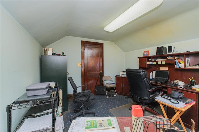 carpeted home office featuring lofted ceiling