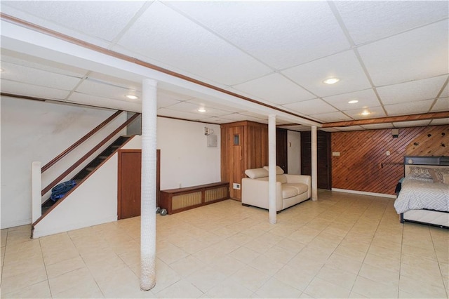finished basement featuring recessed lighting, wooden walls, and a paneled ceiling