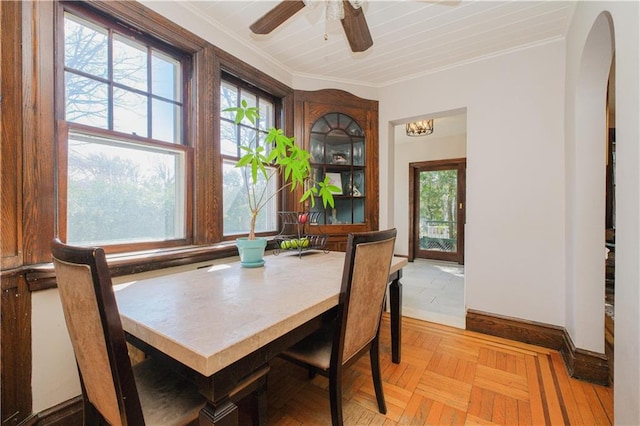 dining room with arched walkways, crown molding, a ceiling fan, and a wealth of natural light