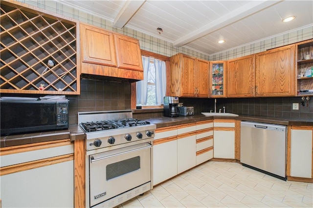 kitchen featuring luxury stove, backsplash, dishwasher, black microwave, and beam ceiling