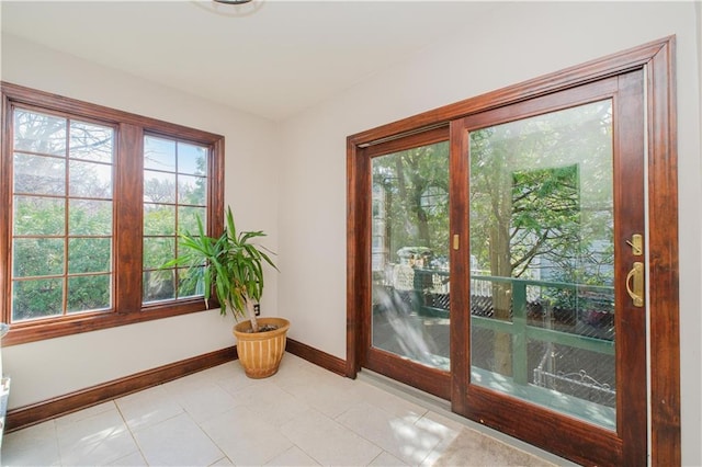 doorway to outside featuring light tile patterned floors and baseboards