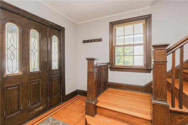 entryway with stairway, light wood-style flooring, baseboards, and ornamental molding