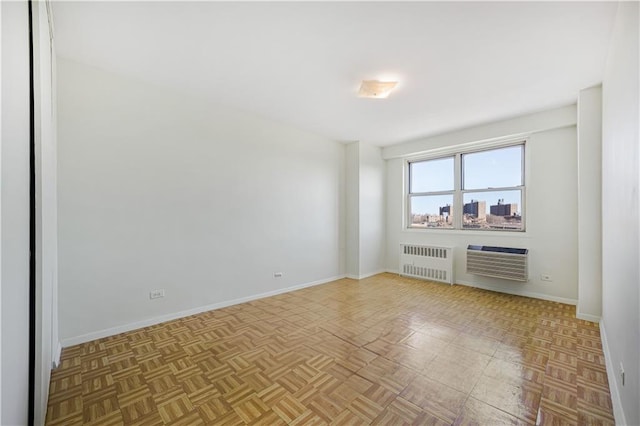 spare room with radiator and baseboards
