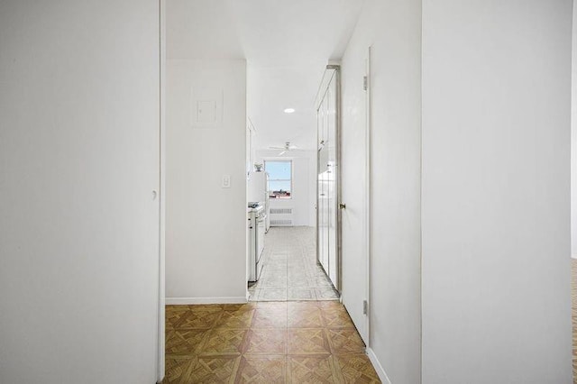 corridor with baseboards and radiator heating unit