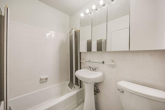 full bathroom with tile walls, decorative backsplash, toilet, and  shower combination