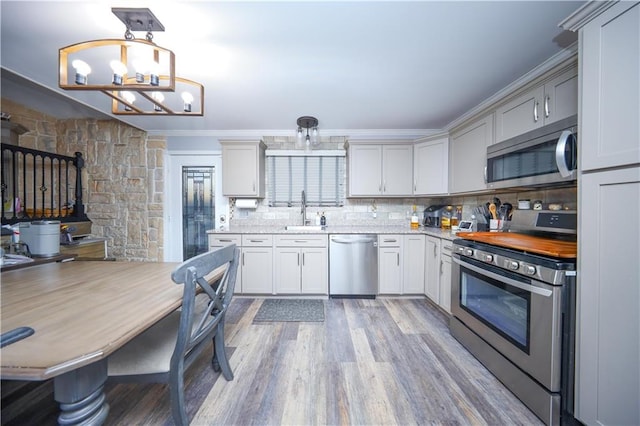 78 Darnell Ln, Staten Island, NY 10309 - kitchen featuring crown molding, a sink, light wood-style flooring, appliances with stainless steel finishes, and backsplash