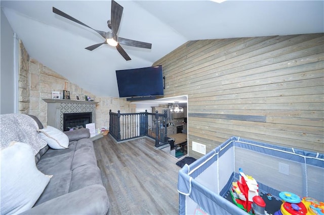 78 Darnell Ln, Staten Island, NY 10309 - living room featuring wooden walls, a ceiling fan, wood finished floors, lofted ceiling, and a tile fireplace