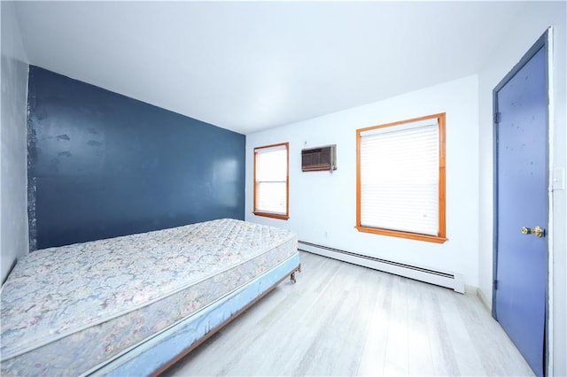 bedroom featuring baseboard heating and wood finished floors