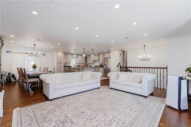 living area featuring an inviting chandelier, crown molding, and recessed lighting