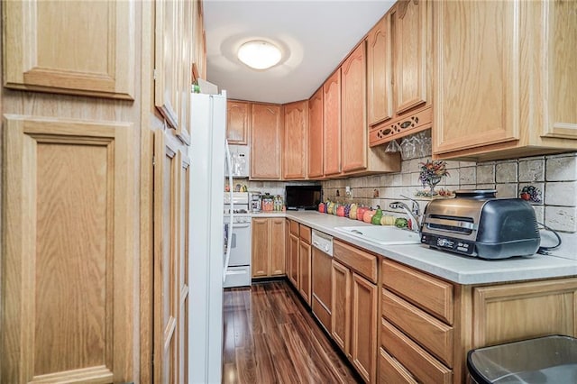 kitchen featuring a sink, dark wood finished floors, light countertops, and white appliances