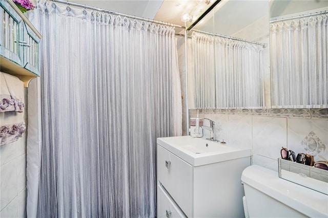 bathroom featuring tile walls, toilet, vanity, and a shower with curtain