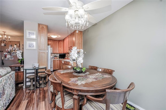 dining room with a chandelier, ceiling fan, dark wood-style flooring, and baseboards