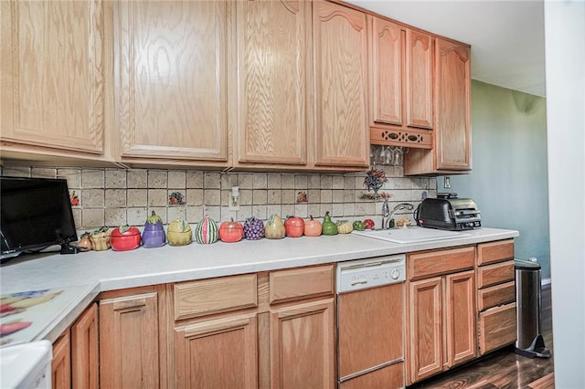 kitchen featuring paneled dishwasher, a sink, light countertops, and backsplash