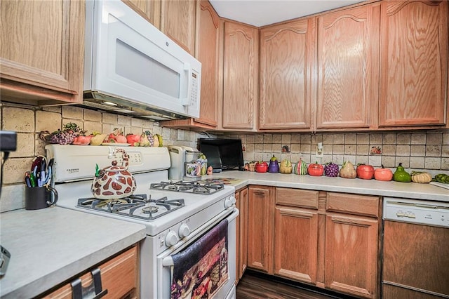 kitchen with white appliances, light countertops, tasteful backsplash, and dark wood-style floors