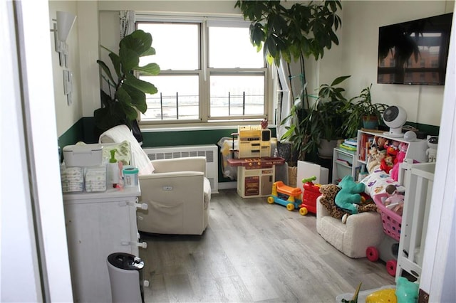 12399 Flatlands Ave Unit 6L, Brooklyn, NY 11207 - recreation room featuring radiator heating unit and wood finished floors